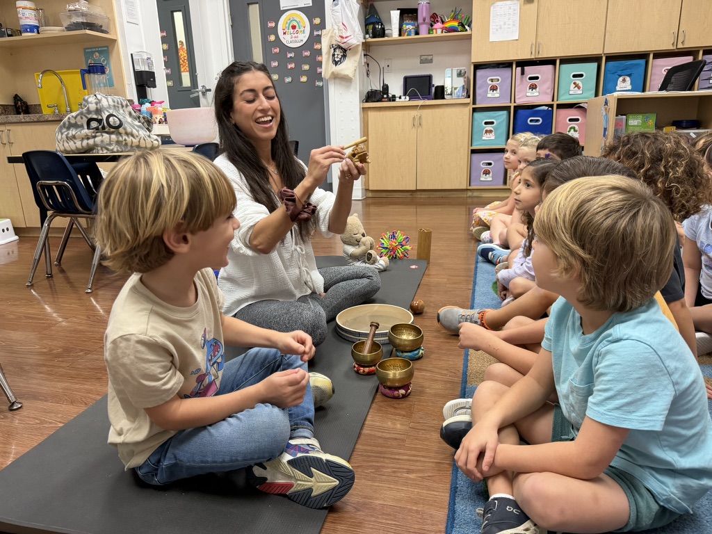 Aimee sharing sound bowls with children