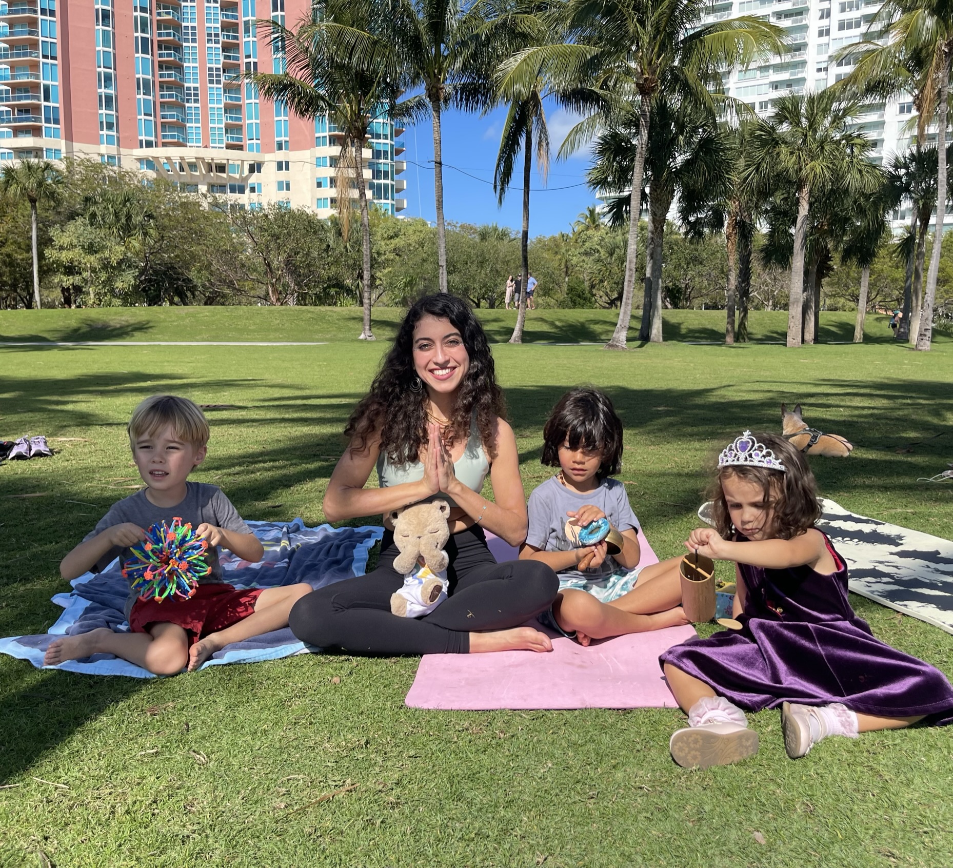 Aimee leading a kids yoga circle in the park